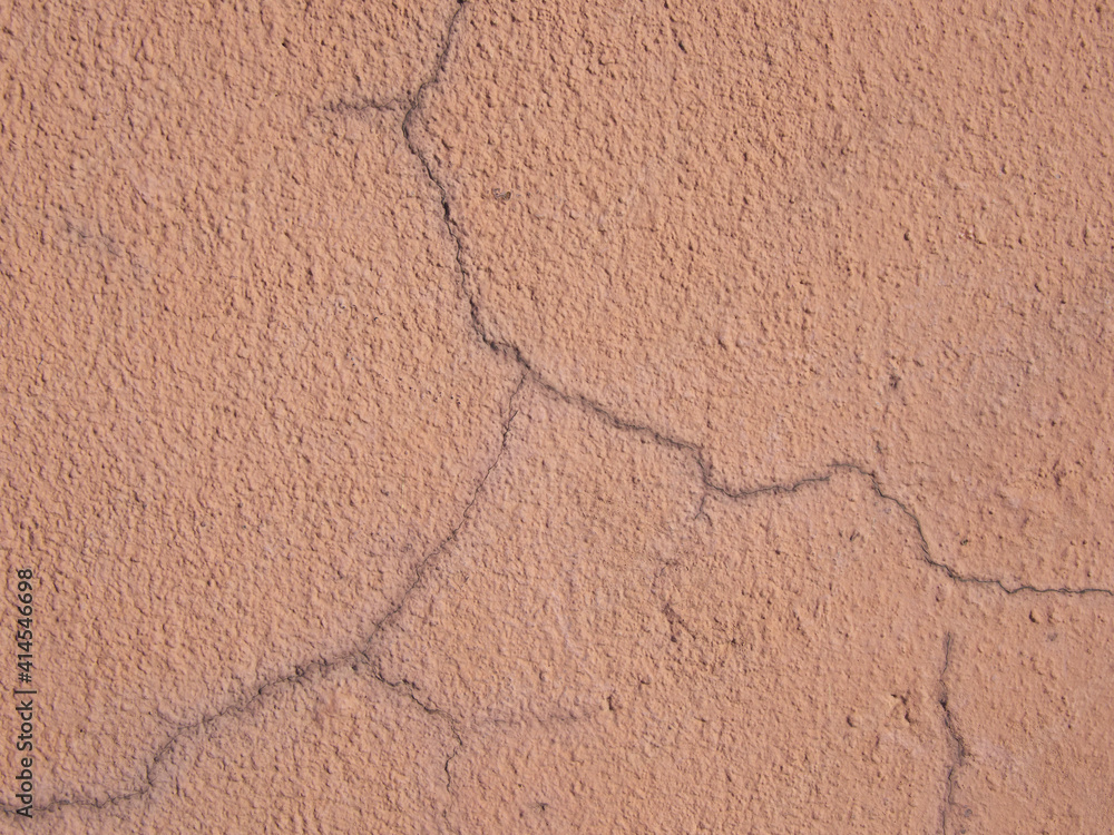 Obraz premium Light brown wall. Cracks in the plaster.