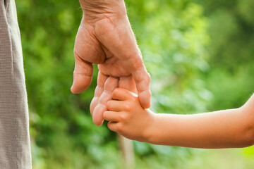 the parent holding the child's hand with a happy background