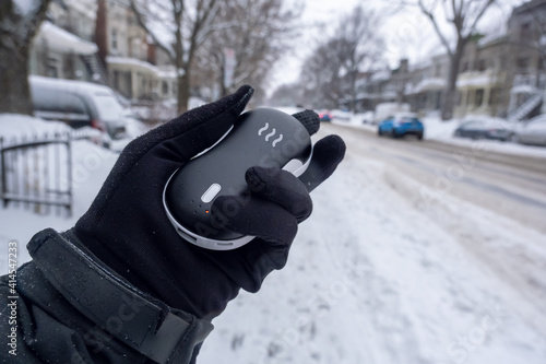 Closeup of an electric pocket hand warm during snow fall