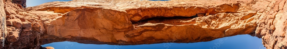 Close up of upper part of red sandstone arch against sky in Arches national park in Utah, America