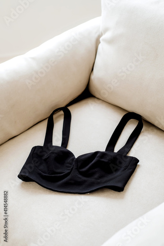 Black cropped top on an armchair. Stylish women's clothes. Interior design.