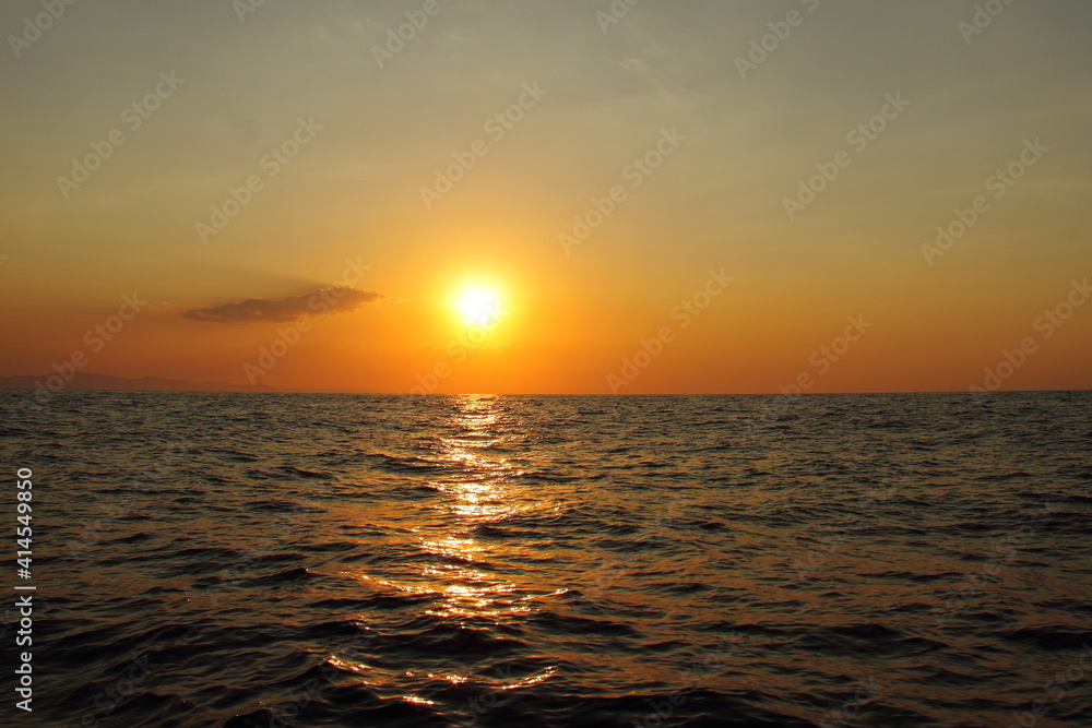 Orange bright sunset under the ocean. Sun reflection on water scenic, yellow dusk, peaceful nature landscape