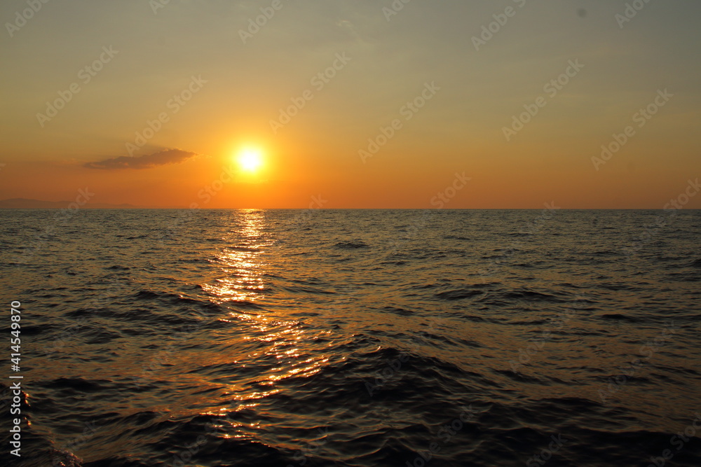 Orange bright sunset under the ocean. Sun reflection on water scenic, yellow dusk, peaceful nature landscape