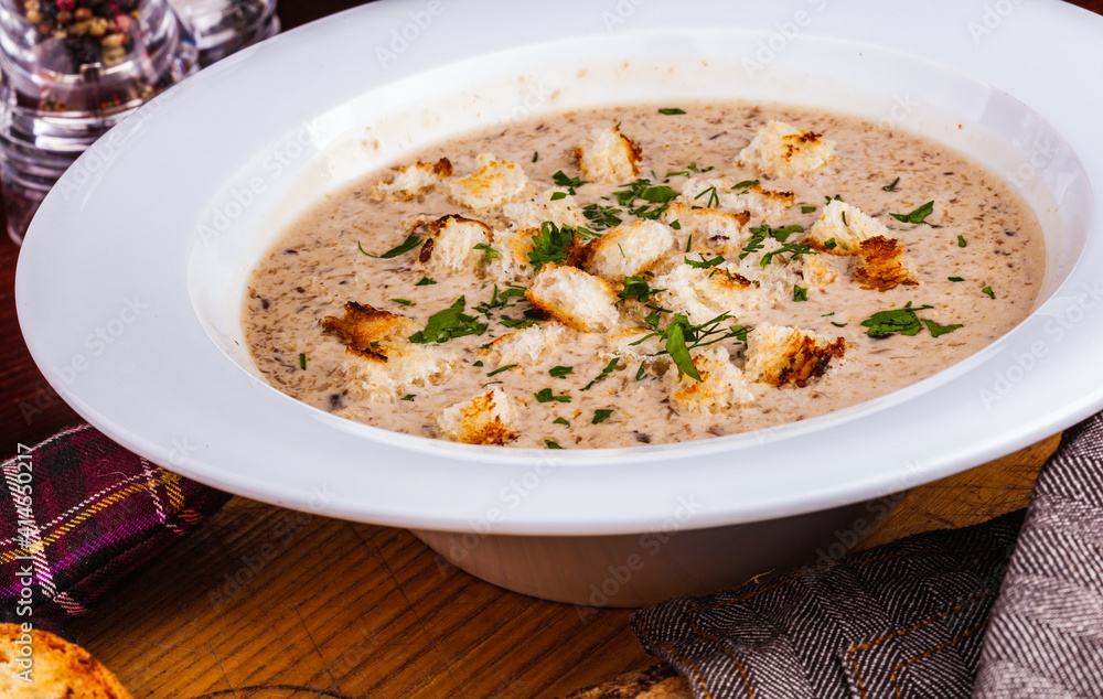 Mushroom cream soup with croutons in white plate