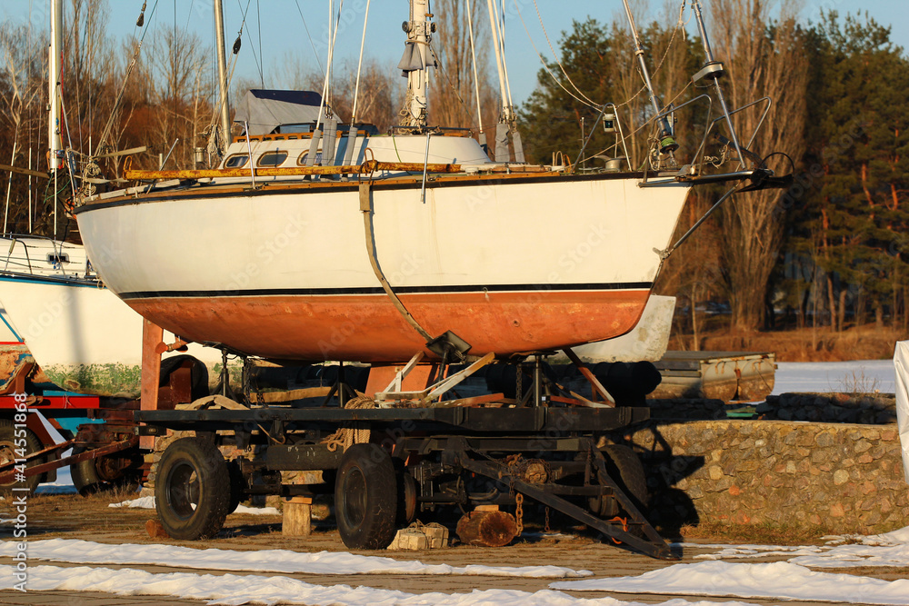 Obraz premium Old sailboats and yachts on the shore at winter