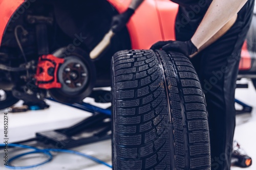 Changing car tire and wheel in the professional car mechanical service © Daniel Jędzura