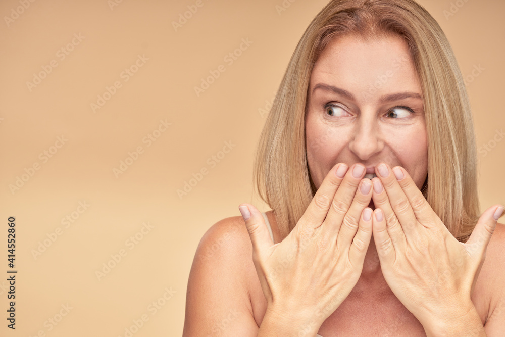 Surprised woman posing in studio on beige background Surprised woman posing in studio on beige background