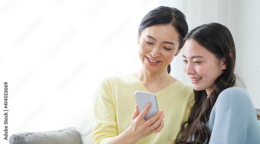 リビングでスマートフォンを使う親子