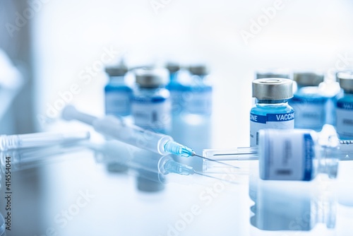 Some ampoules with covid-19 vaccine and syringe injection. Pandemic time. photo