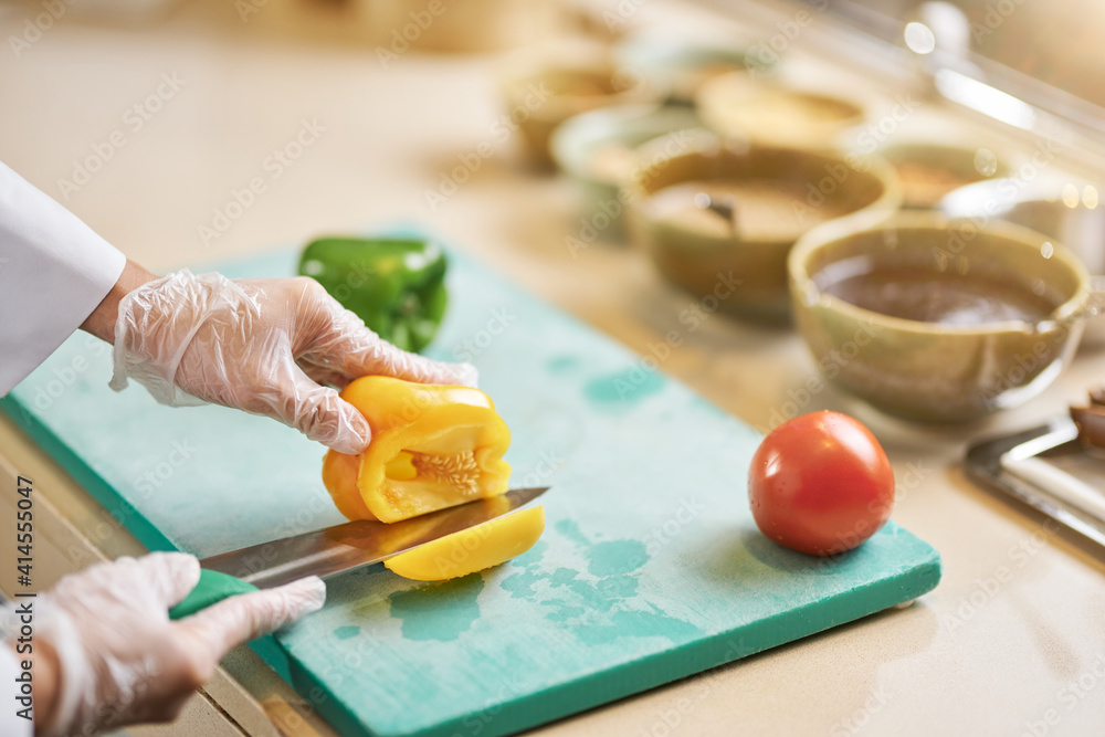 Skilled chef cutting into a fresh bell pepper Skilled chef cutting into a fresh bell pepper