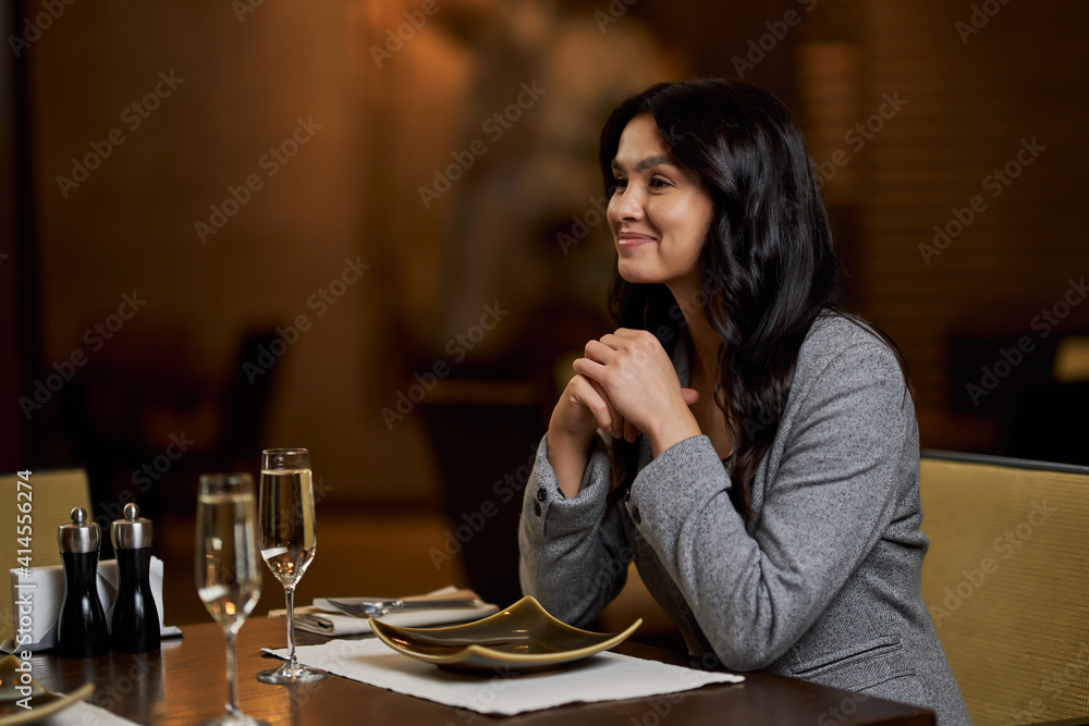 Lovely young lady smiling at the restaurant table
