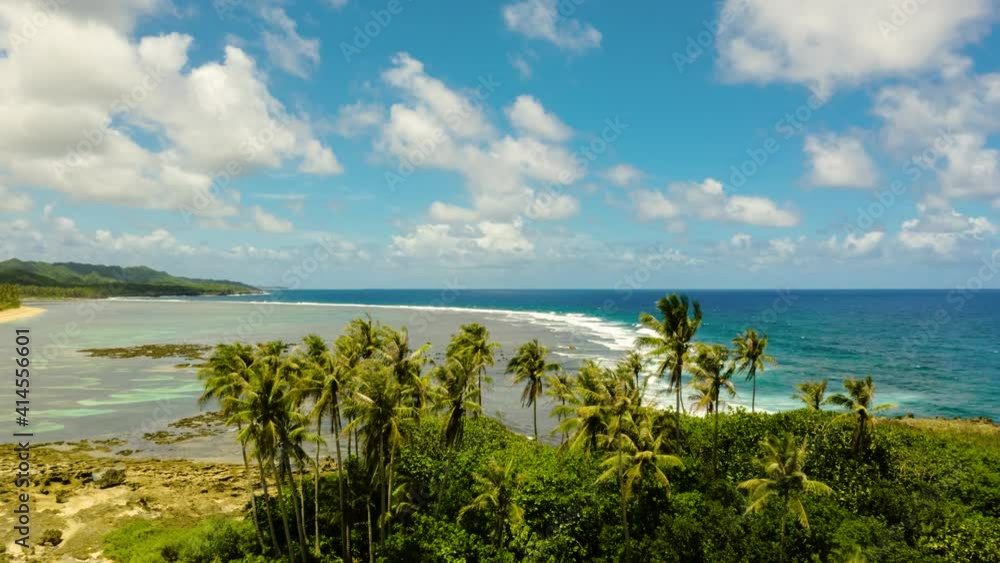Time lapse: Coastline island with palm trees and blue sky with clouds. Blue ocean and waves. Siargao, Philippines. Time lapse: Coastline island with palm trees and blue sky with clouds. Blue ocean and waves. Siargao, Philippines.