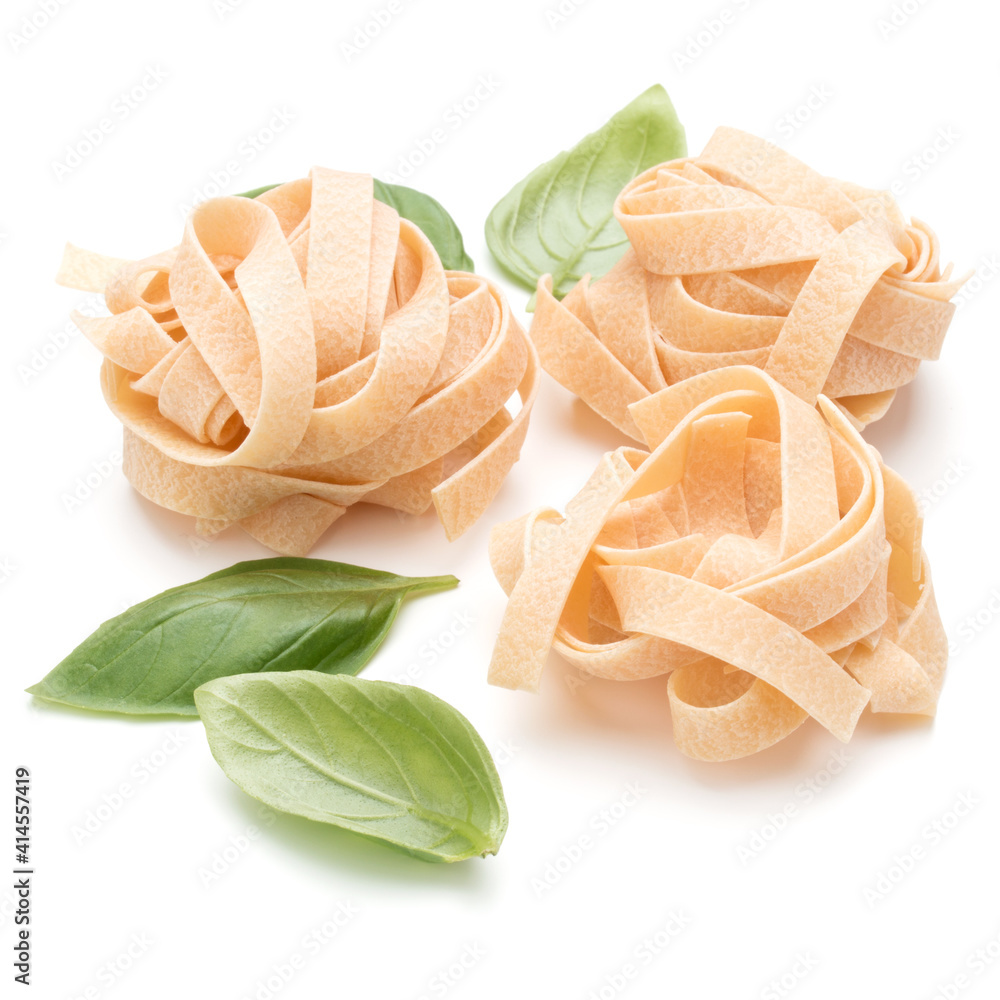 Italian pasta fettuccine nest and basil leaves  isolated on white background cutout