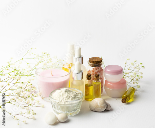 Spa and wellness concept. Set of natural cosmetic products such as serums, oils, cosmetic clay, aromatic candles and massage stones on white background Skin care concept
