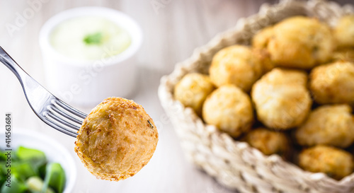 Fried rice ball served on the fork, spot focus. Typical Brazilian fried food photo