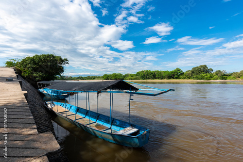 Neiva, Huila, Colombia. May 2019: Panoramic landscape with blue boat on the bank of the Magdalena river. photo