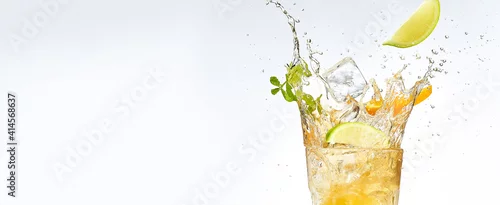 Obraz  z motywem fresh fruits falling into cocktail glass, splashing on white background.