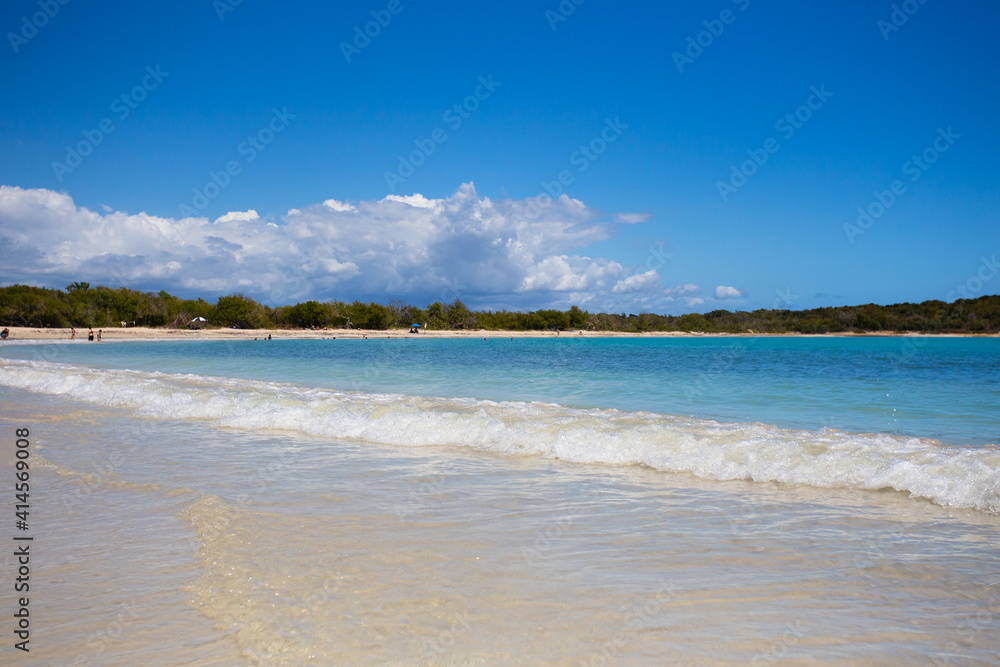 Idyllic beach scene with clear blue water, blue sky and sandy shore seen from Puerto Rico