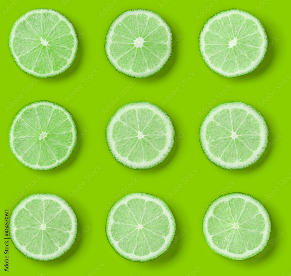Fruit pattern of lime slices on green background. Flat lay, top view. Fruit pattern of lime slices on green background. Flat lay, top view.