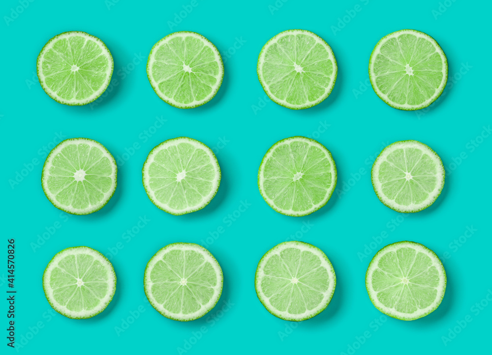 Fruit pattern of lime slices on blue background. Flat lay, top view.