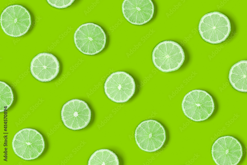 Fruit pattern of lime slices on green background. Flat lay, top view. Fruit pattern of lime slices on green background. Flat lay, top view.