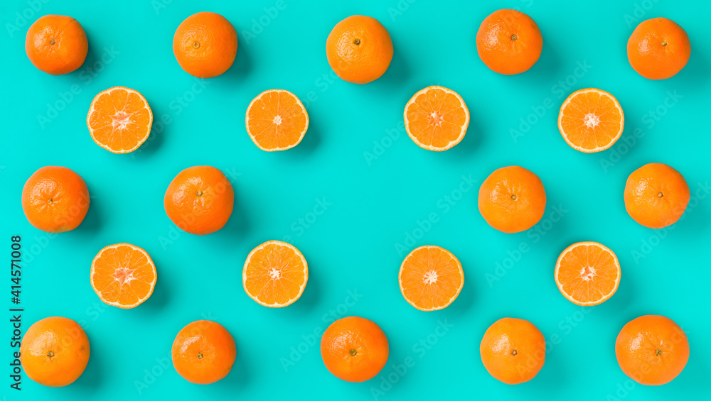 Fruit pattern of fresh mandarin slices on blue background. Flat lay, top view. Pop art design, creative summer concept. Half of citrus in minimal style. Tangerine. Fruit pattern of fresh mandarin slices on blue background. Flat lay, top view. Pop art design, creative summer concept. Half of citrus in minimal style. Tangerine.