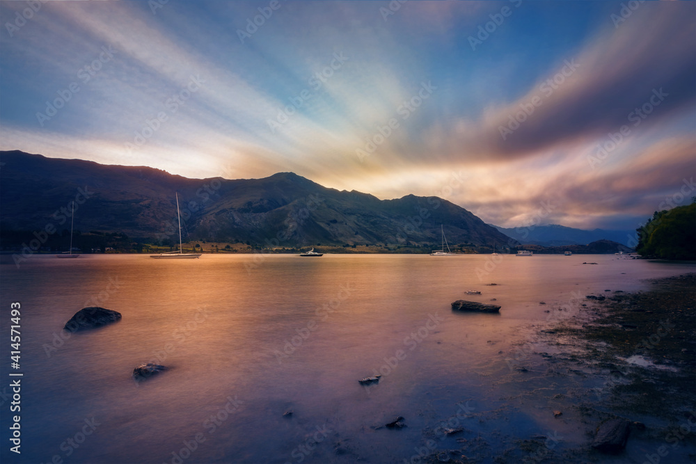 Blue and Gold Sunset at Wanaka Lake -view from Eely Point Recreation Reserve. Wanaka is a popular ski and summer resort town in the Otago Region of New Zealand, South Island.