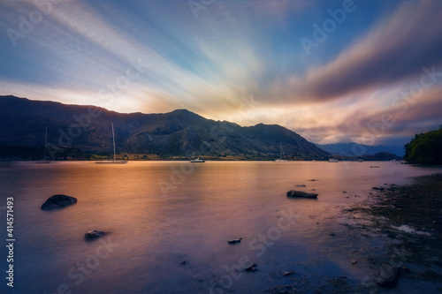 Blue and Gold Sunset at Wanaka Lake -view from Eely Point Recreation Reserve. Wanaka is a popular ski and summer resort town in the Otago Region of New Zealand, South Island.