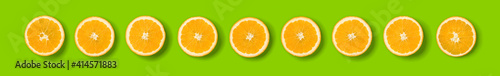 Fruit pattern of orange slices on green background. Flat lay  top view. Banner  seamless pattern  creative summer food concept.