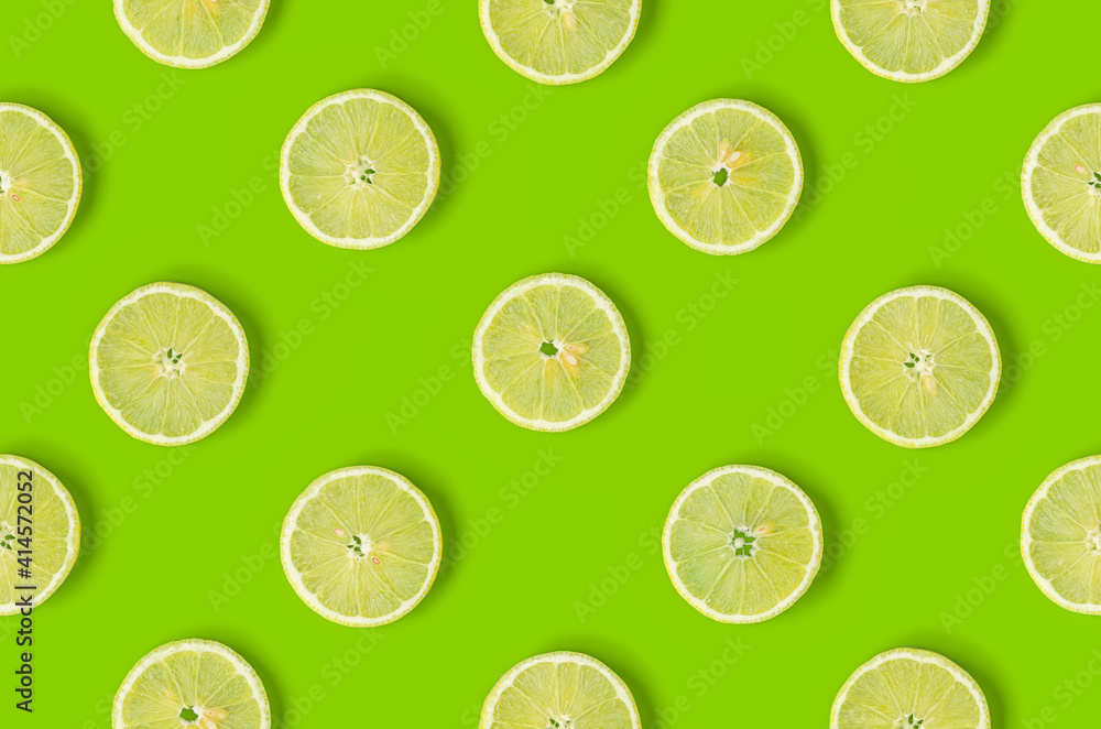  Fruit pattern of lemon slices on green background. Flat lay, top view. Seamless pattern.