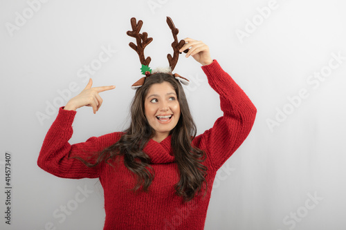 Photo of positive girl point finger at deer headband Christmas