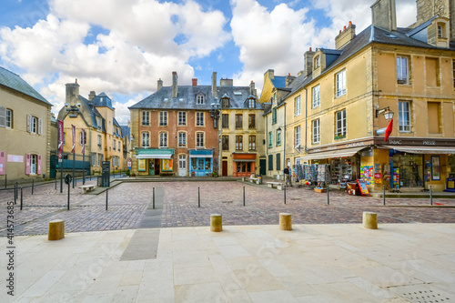 Fototapeta Naklejka Na Ścianę i Meble -  The small square outside the entrance to the Bayeux Cathedral, with colorful shops and cafes in the Normandy town of Bayeux, France.