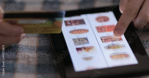 Browsing fast food menu on tablet and making online order. Online shopping concept.