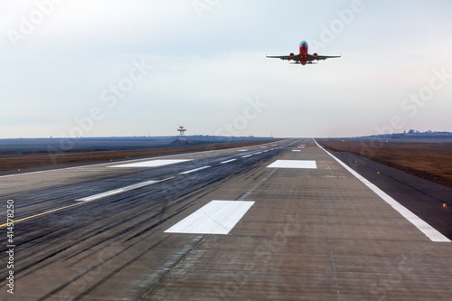Plane is landing . Airplane over the runway strip
