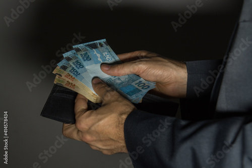 Imagem mostrando dinheiro brasileiro em situação que pode ser de negócios, compra, pagamentos ou até mesmo corrupção e subornos. photo