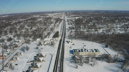 Busy 4 lane road partially cleared after a snow storm