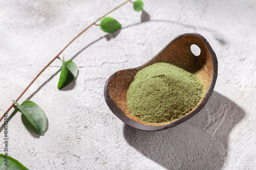 Moringa powder in wooden bowl on white background (Moringa oleifera) photo