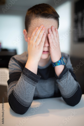 worried boy holding his face