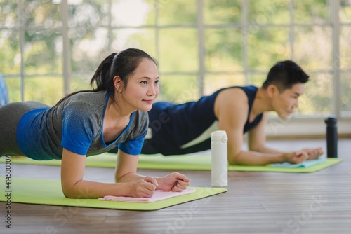 Adult asian man and woman family wearing sport outfit do exercise workout yoga for healthy self care at home