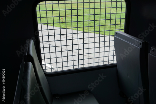 inside paddy wagon, prison car, photo through bars
