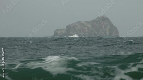 Telephoto shot of Island at the Colombian Atlantic ocean with waves on tidal surge  photo