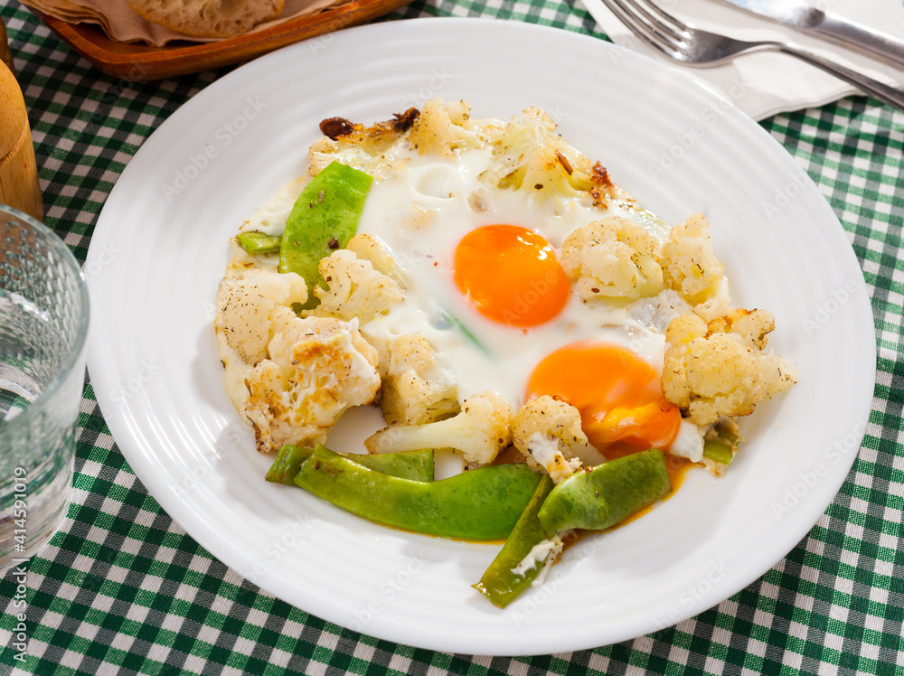 Fresh fried eggs with boiled cauliflower and green beans