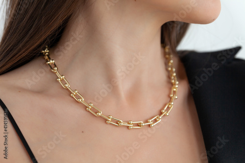 Beautiful model brunette in modern gold metal necklace chain Fototapeta