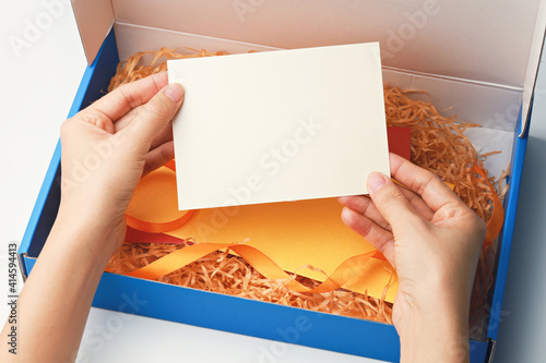 Hands holing blank card from gift box. Concept of gift card surprise.