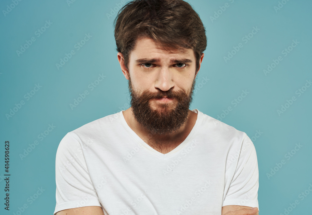 Portrait of a handsome man on a blue background with a cropped beard look Portrait of a handsome man on a blue background with a cropped beard look