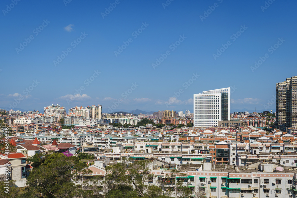 Xiamen city skyline with modern office buildings and residential district against blue sky