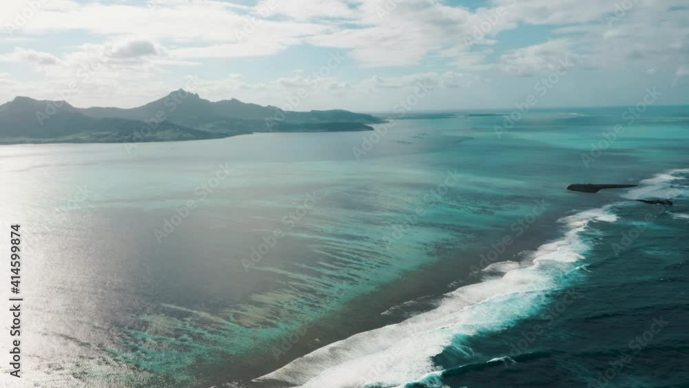 Waves crashing in over reef outside tropical island Mauritius. Beautiful scenery and landscape. Aerial wide shot. Waves crashing in over reef outside tropical island Mauritius. Beautiful scenery and landscape. Aerial wide shot.