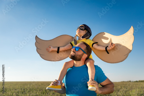 Father and son playing against blue summer sky background photo