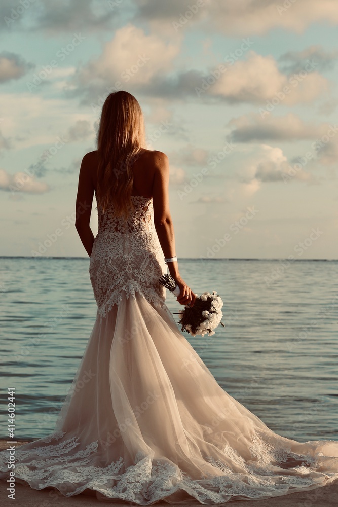 wedding photo where is the bride in white dresses and bouquet flowers in the hands against the background of the sea wedding photo where is the bride in white dresses and bouquet flowers in the hands against the background of the sea