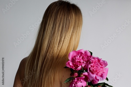 girl with long blond hair and beautiful bouquet flowers pink peonies